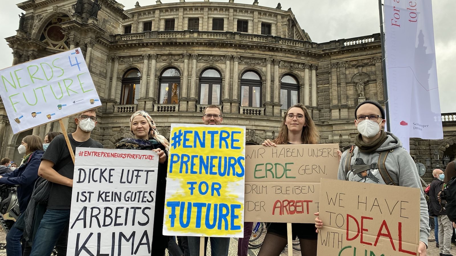 KI generiert: Das Bild zeigt eine Gruppe von Menschen, die an einer Demonstration für Klimaschutz und eine bessere Zukunft teilnehmen, mit Schildern, die Botschaften wie "#Entrepreneurs for Future" und Forderungen nach besserer Luft und Klimaschutz tragen.